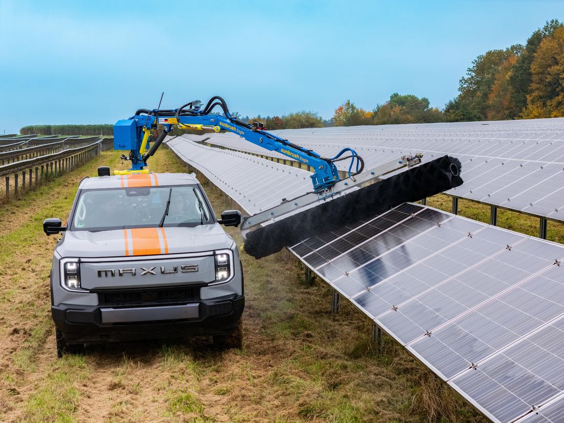SunBrush® Pick-Up Eagle montado sobre una camioneta pick-up, limpiando una hilera de módulos en un parque solar