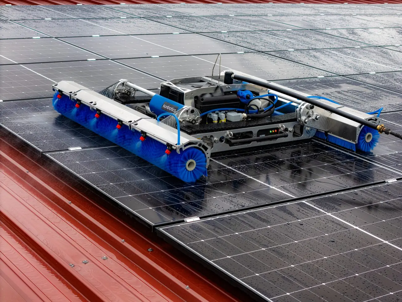 Robot de limpieza sunbotics trabajando sobre módulos fotovoltaicos en un techo